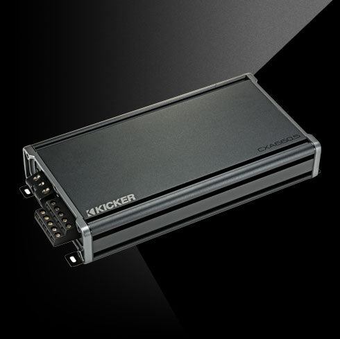 Angled top view of KICKER CXA660.5 car amplifier showing compact chassis and terminal connections.