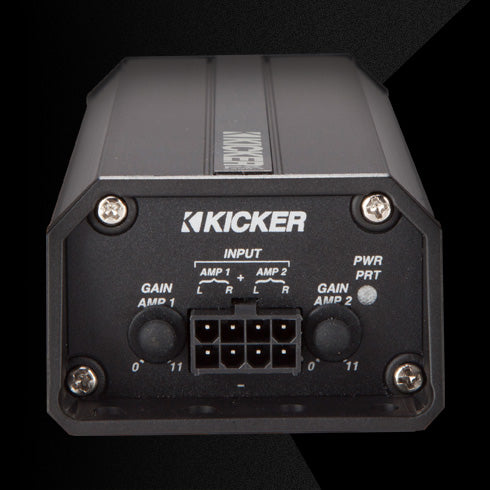 Rear view of KICKER PX amplifier showing input connector, dual gain knobs, and power indicator lights.