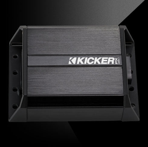 Top view of rugged KICKER PX amplifier with black aluminum casing and side mounting brackets.