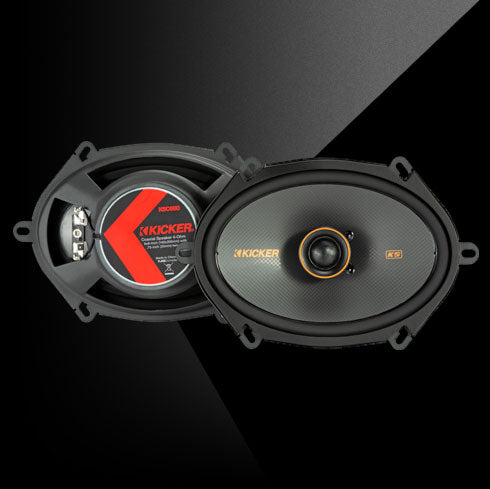 Pair of KICKER KS-Series 5x7-inch coaxial car speakers with black cones, orange trim, and silk-dome tweeters, shown front and back for design and branding details.